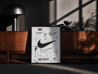 Black-framed Nike Swoosh Black and White Typography print on the floor in front of a dark wooden console