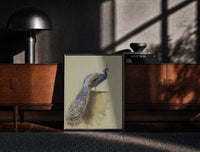 Black-framed peacock with full tail perched on ledge vintage art print print on a moody console with designer…