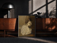 Black-framed seated woman in white dress vintage art print print on a moody console with designer coffee-table books