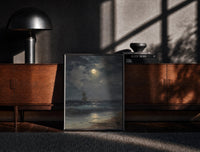 Black-framed tall ship at sea under full moon vintage art print print on a moody console with designer coffee-table books