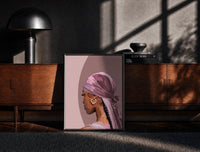 Black-framed Black Woman in a Pink Durag print on the floor in front of a dark wooden console