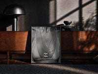 Black-framed Chanel CC Necklace Black & White framed poster print on a moody console with designer coffee-table books