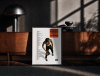 Black-framed Travis Scott Rodeo Anniversary print on the floor in front of a dark wooden console