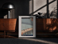 Black-framed Hiroshige Sudden Shower Ohashi print on the floor in front of a dark wooden console