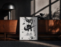 Black-framed KAWS Companion Air Jordan Sneakers framed poster print on a moody console with designer coffee-table books