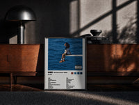 Black-framed SZA SOS Album Tracklist print on the floor in front of a dark wooden console
