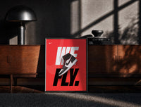 Black-framed Nike Air Jordan 1 We Fly print on the floor in front of a dark wooden console