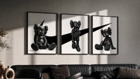 KAWS x Nike Monochrome Companion framed poster set of 3 triptych in three black frames on a grey wall above a leather sofa