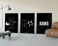 KAWS Companion XX Nike framed poster set of 3 three-panel set displayed beside a brown leather sofa
