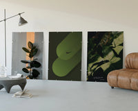 Nike Botanical framed poster set of 3 three-panel set displayed beside a brown leather sofa