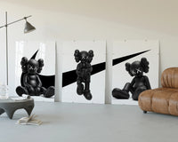 KAWS x Nike Monochrome Companion framed poster set of 3 three-panel set displayed beside a brown leather sofa