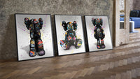 KAWS Companion Graffiti framed poster set of 3 three-piece set leaning on parquet beside a vintage loft door