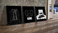 KAWS Monochrome Statement three-piece set leaning on parquet beside a vintage loft door