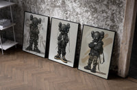 KAWS Nike Street set of three black-framed prints leaning against a raw-plaster wall
