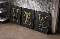 KAWS LV Feat. XX set of three black-framed prints leaning against a raw-plaster wall
