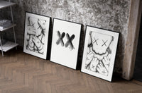 KAWS XX Outline Sketch set of three black-framed prints leaning against a raw-plaster wall