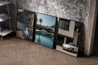 Porsche 911 Coastal framed poster set of 3 set of three black-framed prints leaning against a raw-plaster wall