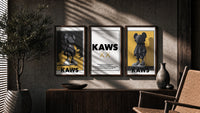 KAWS Monogram Impact triptych in three walnut frames above a sideboard in a warm room