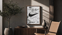Nike Swoosh Black and White Typography poster framed above a fluted sideboard beside a potted tree