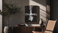 Chanel Black & White Luxury poster framed above a fluted sideboard beside a potted tree