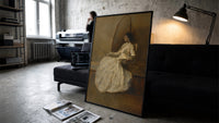 seated woman in white dress vintage art print print in a slim black frame leaning on a dark sofa in a concrete print studio