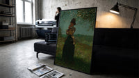 woman under a blossoming tree vintage art print print in a slim black frame leaning on a dark sofa in a concrete print studio