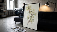 Cliff Rose botanical study with labeled names vintage art print print in a slim black frame leaning on a dark sofa in a…