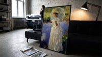 woman with a parasol beside a lily pond vintage art print print in a slim black frame leaning on a dark sofa in a…