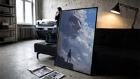 Attack on Titan Colossal framed poster print in a slim black frame leaning on a dark sofa in a concrete print studio