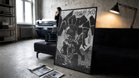 Travis Scott Utopia Album Cover framed poster print in a slim black frame leaning on a dark sofa in a concrete print studio