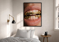 AMG Grillz Gold Grill print in a black frame above a bed with striped linens, a brass wall lamp and a sunlit window