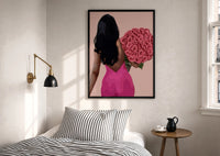 Black Woman Holding Pink Roses print in a black frame above a bed with striped linens, a brass wall lamp and a sunlit window