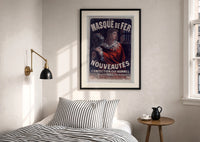 Cheret Au Masque de Fer print in a black frame above a bed with striped linens, a brass wall lamp and a sunlit window