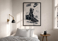 Nike x KAWS Air Force 1 print in a black frame above a bed with striped linens, a brass wall lamp and a sunlit window