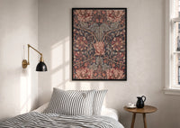 William Morris Honeysuckle print in a black frame above a bed with striped linens, a brass wall lamp and a sunlit window
