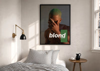 Blond Frank Ocean Album Cover Portrait print in a black frame above a bed with striped linens
