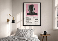 Tyler, The Creator IGOR Tracklist print in a black frame above a bed with striped linens