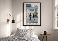 Pink Floyd Wish You Were Here Burning Handshake print in a black frame above a bed with striped linens