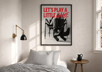 Let's Play a Little Game print in a black frame above a bed with striped linens, a brass wall lamp and a sunlit window