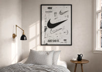 Nike Swoosh Black and White Typography print in a black frame above a bed with striped linens