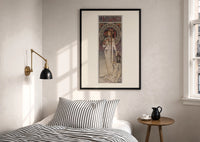 Mucha La Trappistine print in a black frame above a bed with striped linens, a brass wall lamp and a sunlit window