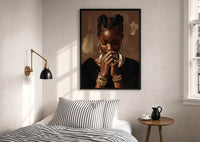 Black Woman with Clasped Hands print in a black frame above a bed with striped linens, a brass wall lamp and a sunlit window