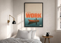 Slow Day at Work Gone Fishing print in a black frame above a bed with striped linens, a brass wall lamp and a sunlit window