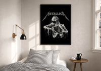 Metallica Decaying Corpse Skeleton print in a black frame above a bed with striped linens