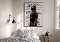 Kendrick Lamar Everything Profile print in a black frame above a bed with striped linens