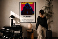 The Weeknd Starboy Album Cover print in a black frame on a sunlit plaster wall, a person looking on beside a mushroom lamp