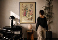 Arthur Rackham Boisterous Group print in a black frame on a sunlit plaster wall, a woman looking on beside a mushroom lamp