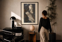 Audubon Snowy Owl print in a black frame on a sunlit plaster wall, a woman looking on beside a mushroom lamp