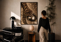 Cheetah Paw and Disco Ball print in a black frame on a sunlit plaster wall, a person looking on beside a mushroom lamp