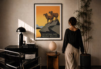 WPA Parks Preserve Wild Life print in a black frame on a sunlit plaster wall, a woman looking on beside a mushroom lamp